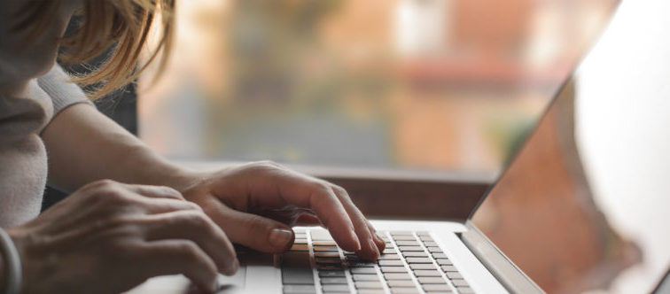 Close-up view on woman who working on laptop